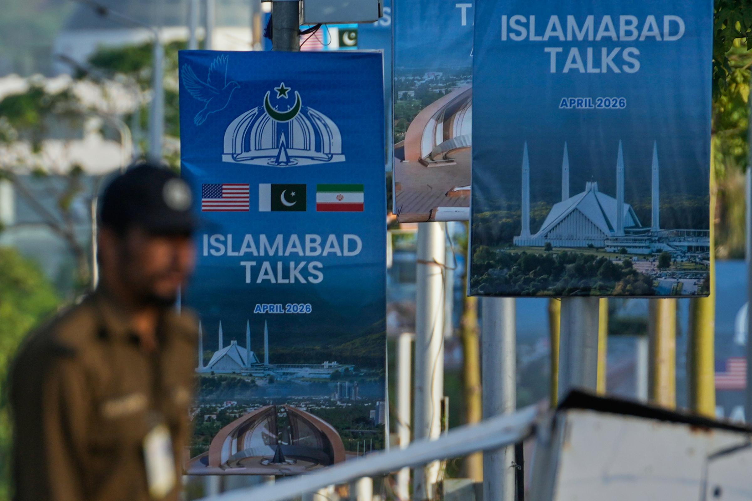 A police officer walks past posters of U.S. and Iran talks near a possible venue in Islamabad, Pakistan, Saturday, April 25, 2026. (AP Photo/Anjum Naveed)