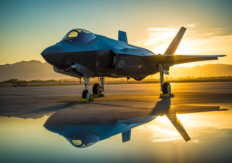 The sun sets behind an Australian F-35A Lighting II aircraft at Luke Air Force Base, Ariz., June 27, 2018. The first Australian F-35 arrived at Luke in December, 2014. Currently six Australian F-35's are assigned to the 61st Fighter Squadron where their pilots train alongside U.S. Air Force pilots. (U.S. Air Force photo by Staff Sgt. Jensen Stidham) Note: This image was created by placing a reflective surface in front of the the camera lens.